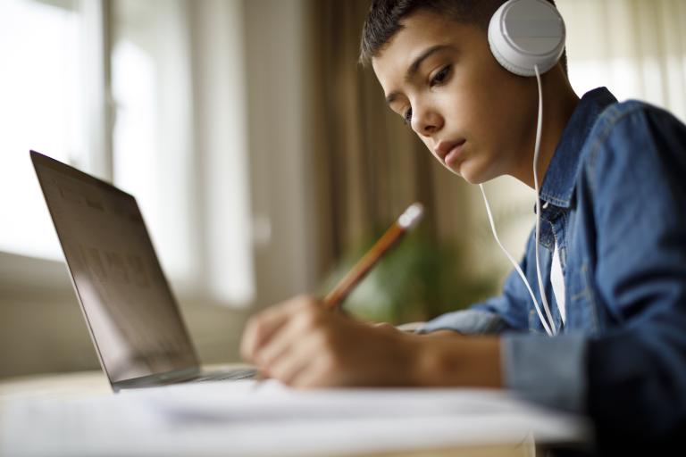 Jongen met laptop en koptelefoon