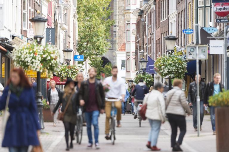 Mensen wandelen en fietsen op straat