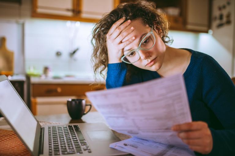 Vrouw kijkt bezorgd naar rekeningen